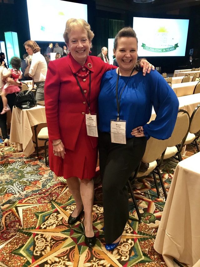 Two women surgeons smiling at a conference