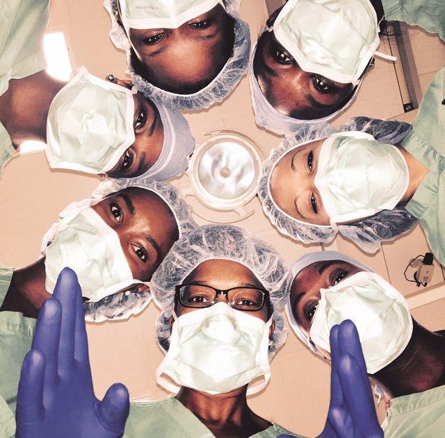 Surgeons in masks photographed from below as if from the operating table
